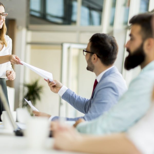 Group of businessmen and businesswomen working together in office.